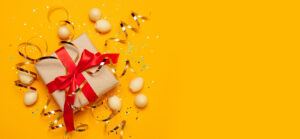 Holiday gift with red ribbon on yellow background